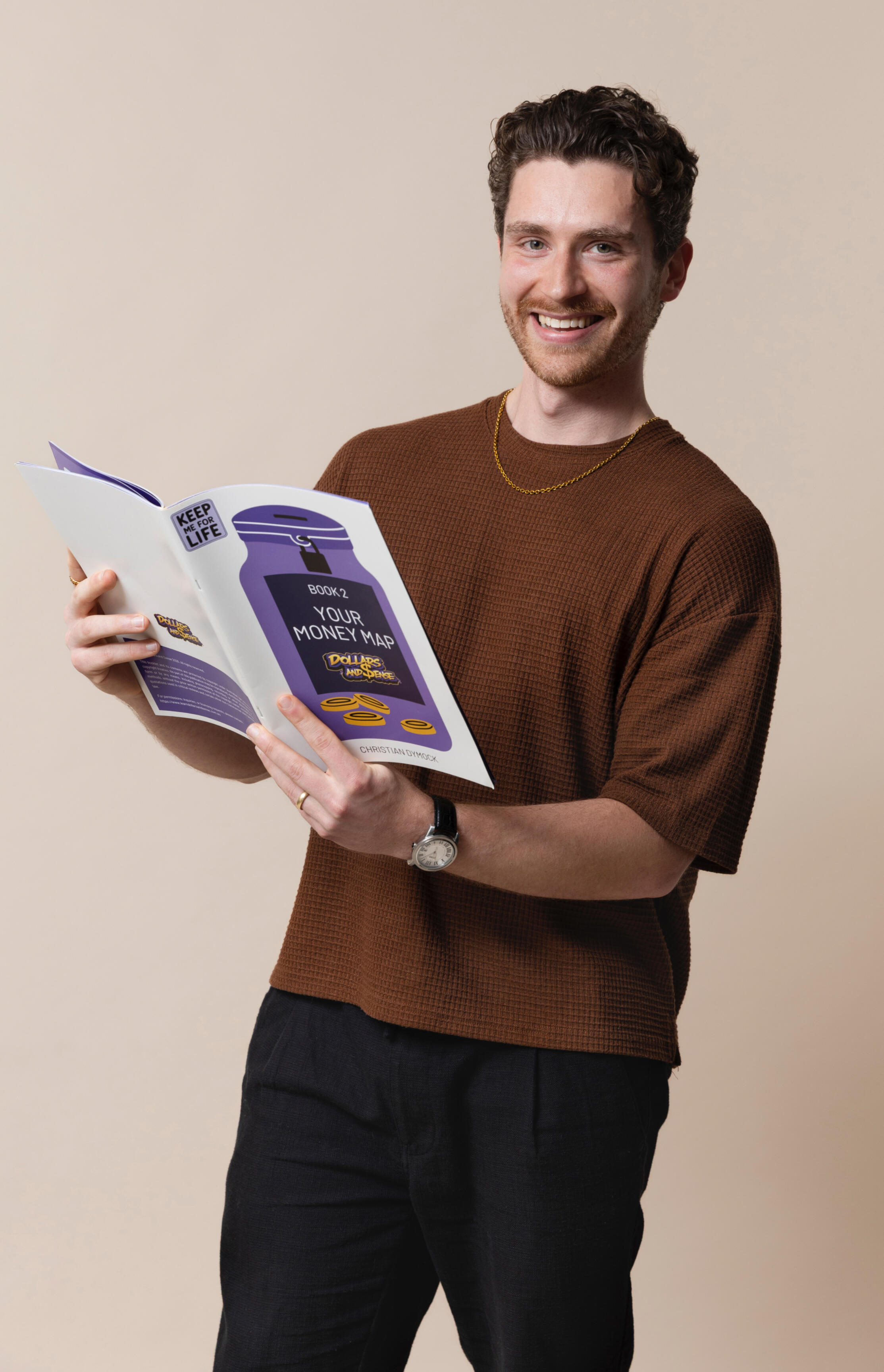 A picture of the founder holding a copy of the program, wearing a brown top and black pants